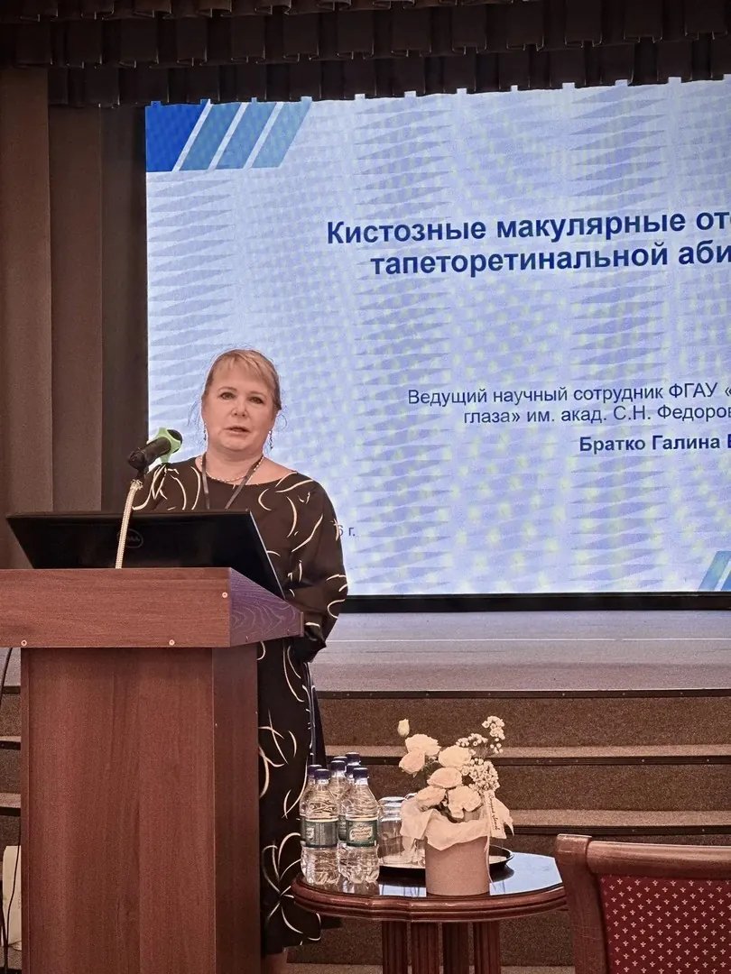 Докладчица у трибуны на фоне слайда о кистозных макулярных отёках