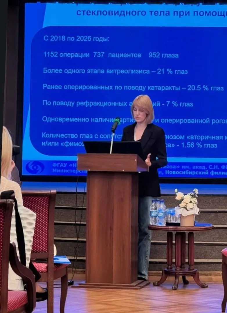 Докладчица у трибуны на фоне слайда со статистикой операций на стекловидном теле